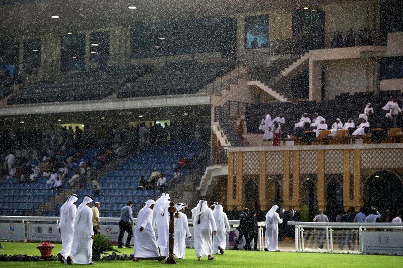 ABU DHABI , UNITED ARAB EMIRATES , November 25  ��� 2018 :- Officials going to take the cover during the rain at the Abu Dhabi Equestrian Club in Abu Dhabi. ( Pawan Singh / The National ) For News/Instagram 