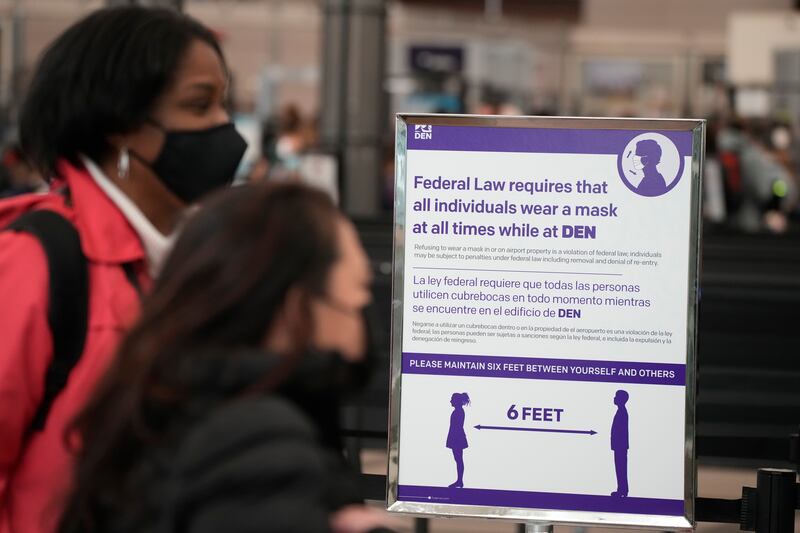 A sign advising travellers to wear a mask at Denver International Airport. AP