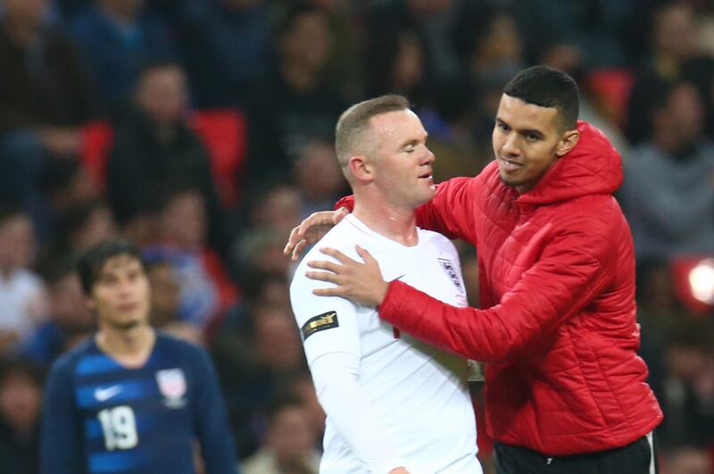 A pitch invader hugs Wayne Rooney of England during the friendly soccer match between England and USA at the Wembley Stadium in London.  EPA