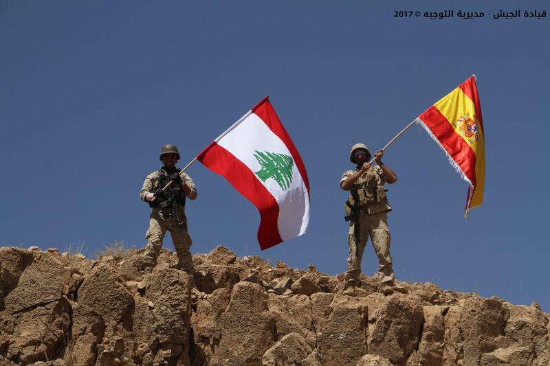 A handout picture released by the Lebanese army on August 19, 2017 shows Lebanese soldiers holding the Spanish flag alongside their own in a show of solidarity with Spain, where attacks claimed by ISIL killed 14 people. Photo via Lebanese army website