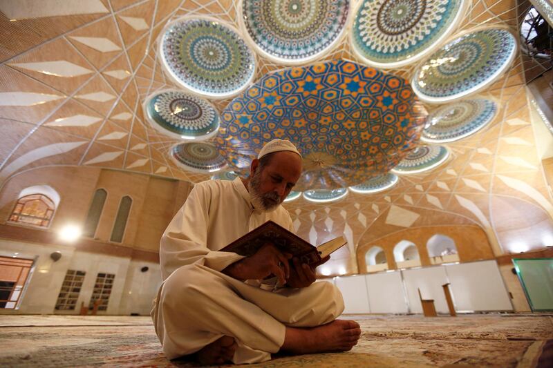 An Iraqi man reads the Koran in an almost empty mosque, following the outbreak of the coronavirus disease (COVID-19), during the holy month of Ramadan in the holy city of Najaf, Iraq. REUTERS