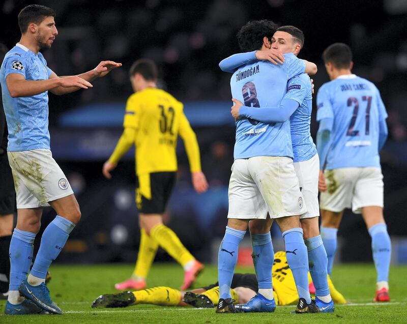 Manchester City's English midfielder Phil Foden (2R) celebrates scoring his team's second goal with Manchester City's German midfielder Ilkay Gundogan during the UEFA Champions League first leg quarter-final football match between Manchester City and Borussia Dortmund at the Etihad Stadium in Manchester, north west England, on April 6, 2021. (Photo by Paul ELLIS / AFP)