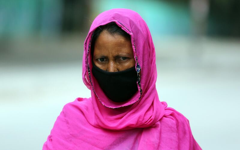epa08681324 An Indian woman wearing a face mask walking in the street in Bangalore, India, 19 September 2020. India has the second highest total of confirmed COVID-19 cases in world.  EPA/JAGADEESH NV