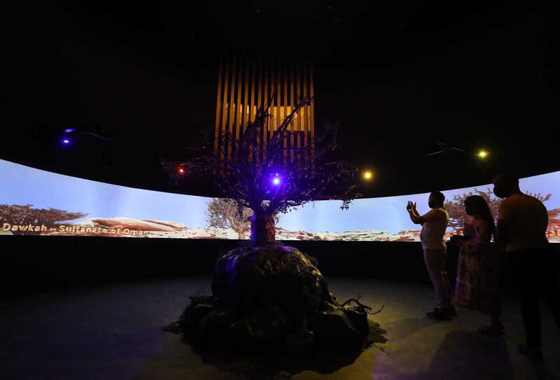 Visitors to the Oman pavilion take pictures of the frankincense tree on the 10th day of Expo 2020 Dubai. Chris Whiteoak / The National
