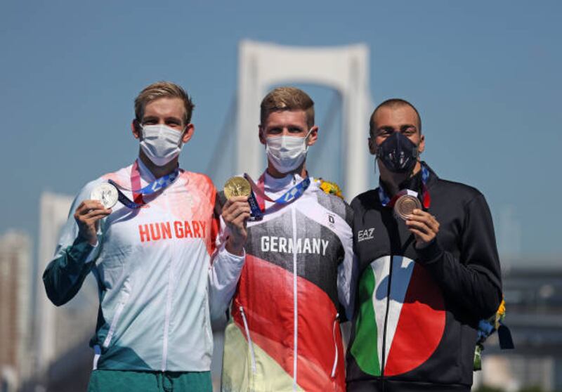 Gold medalist Florian Wellbrock of Team Germany, centre, silver medalist Kristof Rasovszky of Team Hungary, left, and bronze medalist Gregorio Paltrinieri of Team Italy pose after the Men's 10km Marathon Swimming.