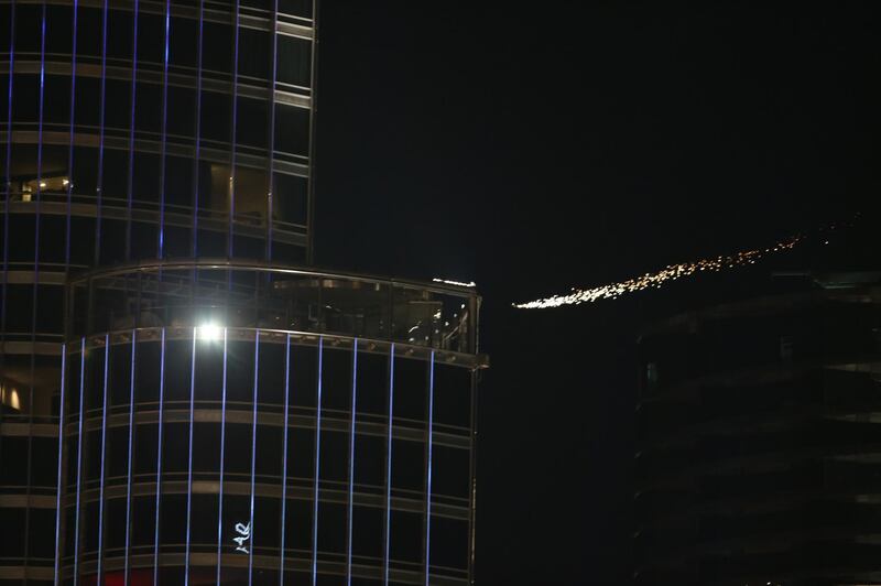 Ski divers with special lights fly over Burj Khalifa, the tallest building in the world, ahead of the celebrations.  EPA