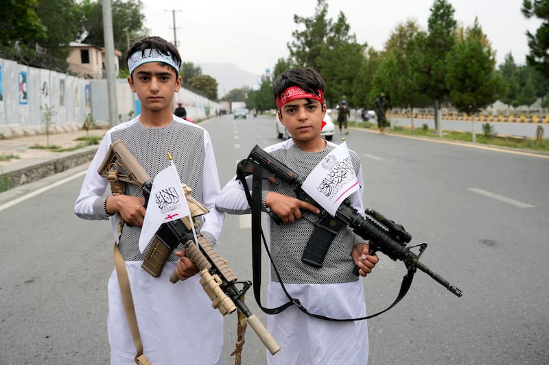 Afghan boys hold weapons as they join the celebrations. AP
