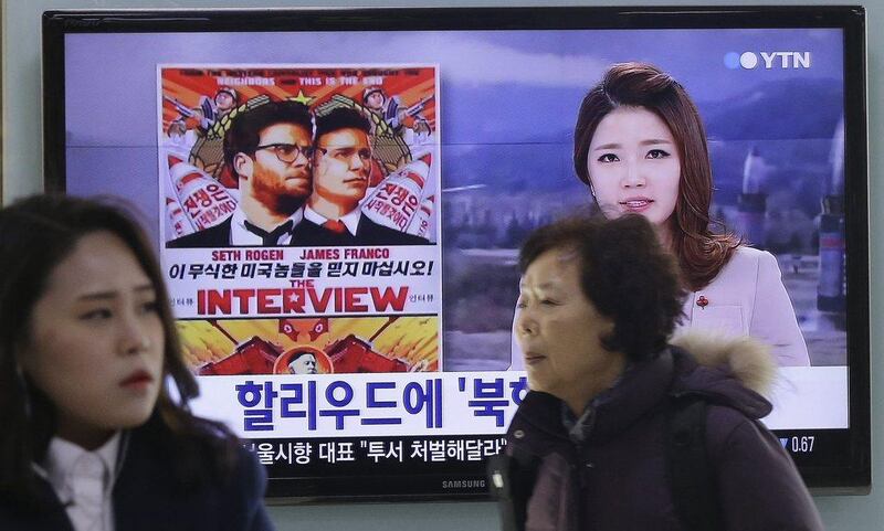 People walk past a TV screen showing a poster of Sony Picture's "The Interview" in a news report, at the Seoul Railway Station in Seoul, South Korea. North Korea hates the Hollywood film that revolves around the assassination of its beloved leader, but the country has had a long love affair with cinema - of its own particular styling. Ahn Young-joon / AP