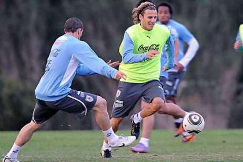 Diego Forlan, centre, dribbles past his Uruguay teammate Diego Perez during pre-World Cup training at Canelones, near Montevideo.