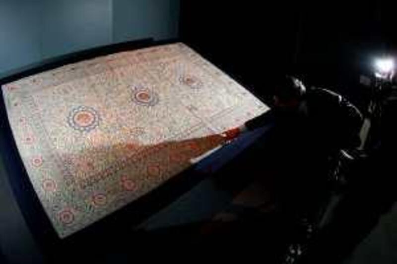 A man points to a detail on the Pearl Carpet of Baroda displayed at the Ritz-Carlton hotel in Doha on March 14, 2009. The carpet, which will be auctioned off at Sotheby's Doha on March 19 with a starting bid of five million US dollars, is made of rubies, sapphires, diamonds, and pearls. It is traditionally believed that the carpet was ordered by the Indian Maharajah Kande Rao Gaekwar of Baroda to be offered as a gift to the tomb of Islam's Prophet Mohammed in the Saudi city of Medina, but due to his death the gift was never delivered and was instead kept as a state treasure. It is not clear when the carpet was taken out of India. AFP PHOTO/KARIM JAAFAR *** Local Caption ***  Nic347509.jpg