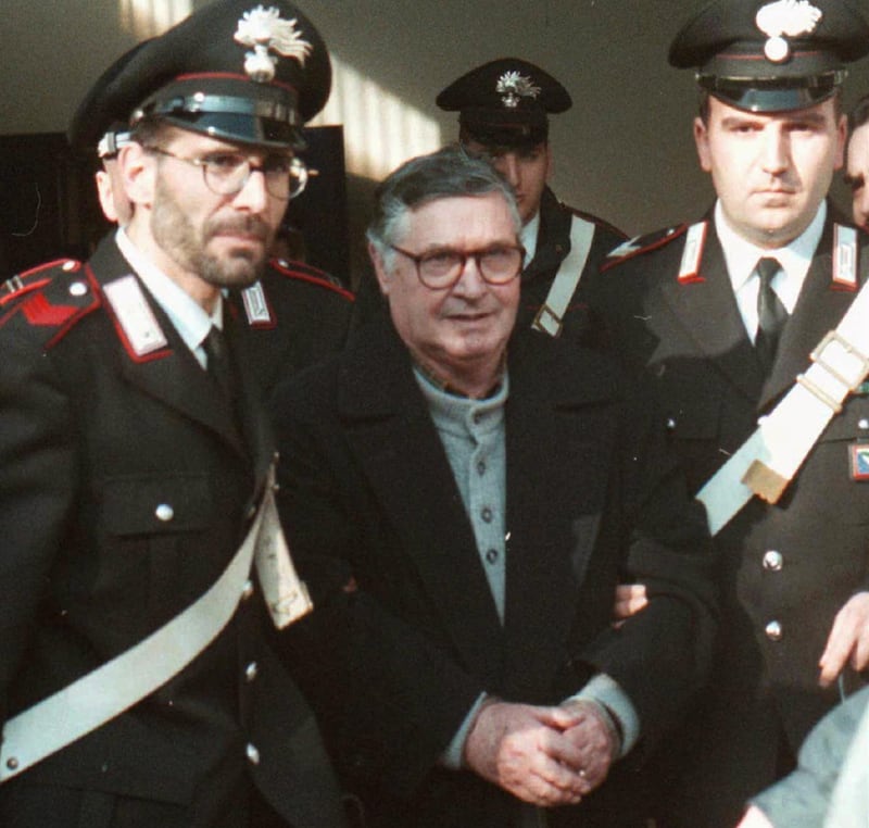 FILE - In this Jan. 16, 1996 file photo, Mafia ''boss of bosses'' Salvatore ''Toto'' Riina, center, enters handcuffed into Bologna's bunker-courtroom, escorted by Carabinieri, Italian paramiliary police, in Bologna, Italy. Italian media is reporting that Mafia â€˜boss of bossesâ€™ Salvatore â€˜Totoâ€™ Riina has died while serving multiple life sentences. He was 87. The justice ministry on Thursday, Nov. 16, 2017,  had allowed his family a bedside visit at a hospital Parma shortly before his death. He had been placed in a medically induced coma after his health deteriorated following two recent surgeries. (AP Photo/Gianni Schicchi, File)