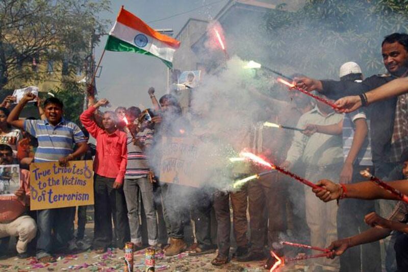 People hold flares and wave India's national flag as they celebrate after India hanged Mohammad Ajmal Kasab, in the western Indian city of Ahmedabad November 21, 2012. India executed Kasab, the lone survivor of a militant squad that killed 166 people in a rampage through the financial capital Mumbai in 2008, hanging him on Wednesday just days before the fourth anniversary of the attack. REUTERS/Amit Dave (INDIA - Tags: CRIME LAW CIVIL UNREST)