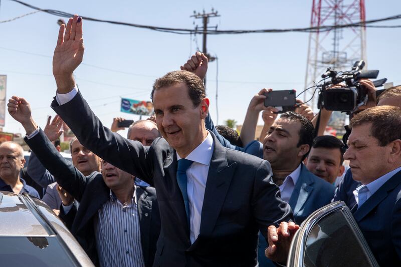 Syrian President Bashar Al Assad waves at a polling station during the presidential elections in Douma, Syria, on May 26, 2021. President Assad issued a decree on Sunday, July 11, 2021, awarding a 50 per cent pay rise to hundreds of thousands of civil servants and military members. AP