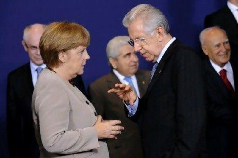 German chancellor Angela Merkel talks with Italian prime minister Mario Monti  during a European Union summit photoshoot.