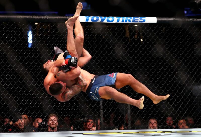 ANAHEIM, CALIFORNIA - AUGUST 17: Christos Glagos is slammed onto the ground by Drakkar Klose in the third round during their Lightweight Bout at UFC 241 at Honda Center on August 17, 2019 in Anaheim, California. (Photo by Joe Scarnici/Getty Images)