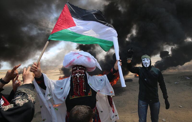 A Palestinian woman holding her national flag in protests in Khan Yunis. Said Khatib / AFP Photo