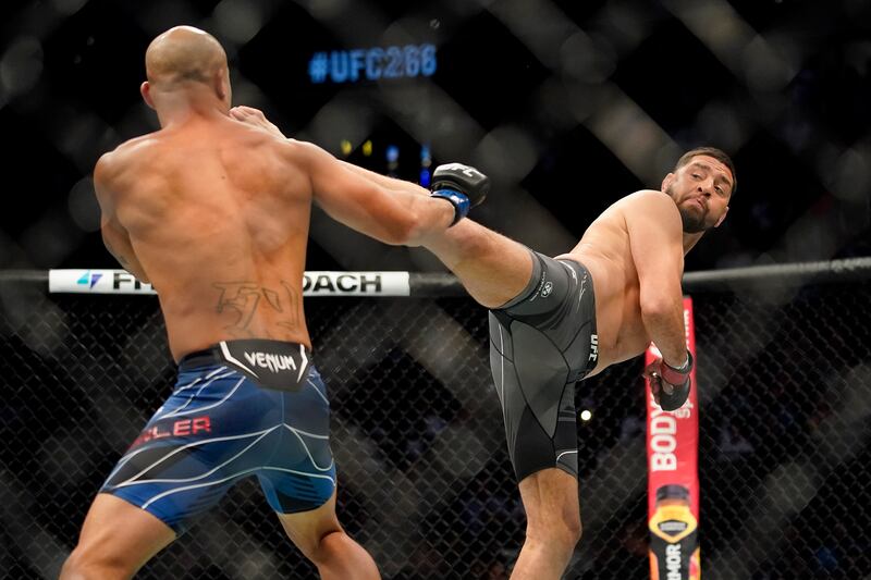 Nick Diaz, right, kicks Robbie Lawler. AP Photo