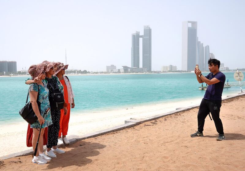 Abu Dhabi, United Arab Emirates, July 23, 2019.  Chinese tourists enjoy the sights at the Heritage Village, Corniche, in spite of the humid weather.
Victor Besa/The National
Section:  NA
Reporter: