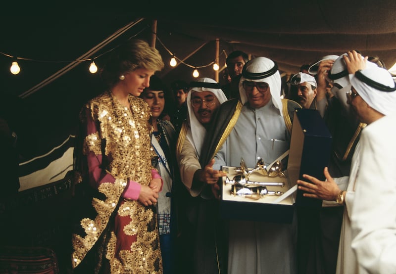 Diana, Princess of Wales, receives the gift of a gold embroidered gown and a silver tea set on a visit to the museum in Kuwait City, in March 1989.  