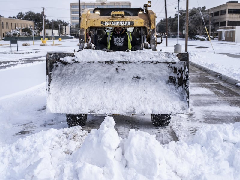 A worker clears snow from a car park in Midland, Texas. Blackouts triggered by frigid weather have spread to more than four million homes and businesses across the central US and parts of Mexico. Bloomberg