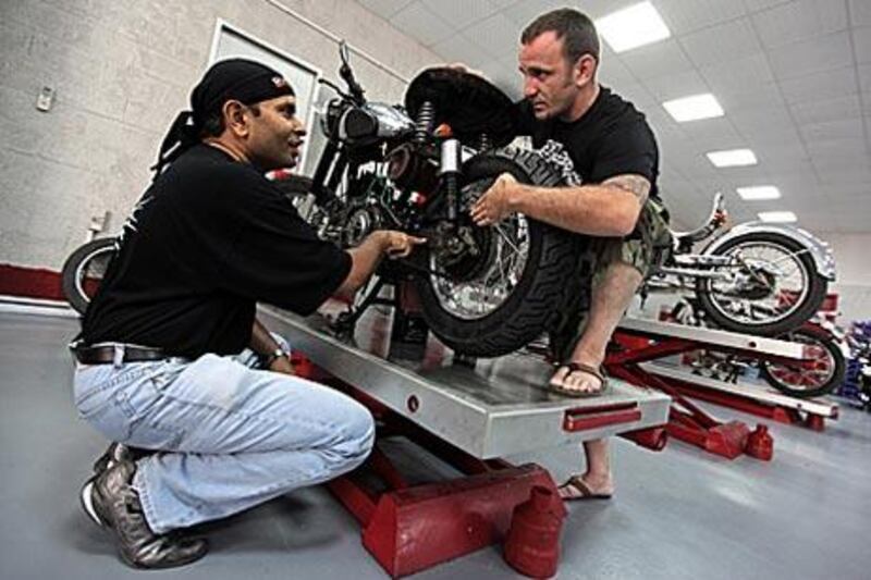 Manupriam, left, gives tips to Marco Moller on how to modify his 1994 Royal Enfield Bullet 500 at Classic Motorcycles.
