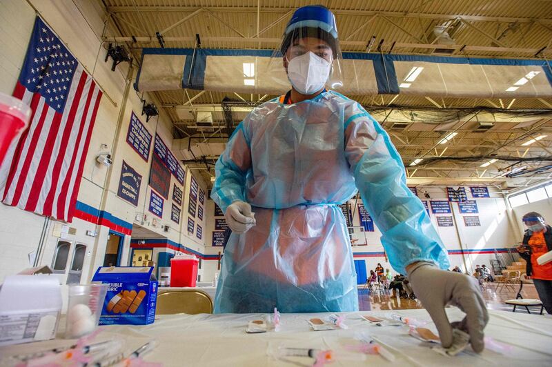 Elvin Toro, 26, a former army medic, organises his syringes before giving out the next dose of the Covid-19 vaccine to a local resident at Central Falls High School in Central Falls, Rhode Island, USA. AFP