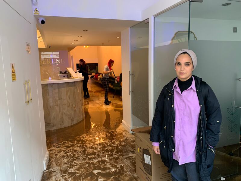 Dr Safa Al-Naher, owner of Serene dentist's surgery in Knightsbridge, stands in the floodwaters. Photo: Laura O'Callaghan / The National