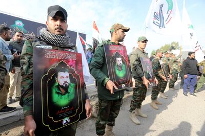 Members of the Iraqi Popular Mobilisation Forces (PMF) carry images of their comrades who were killed in US air strikes in western Iraq on February 4. EPA 
