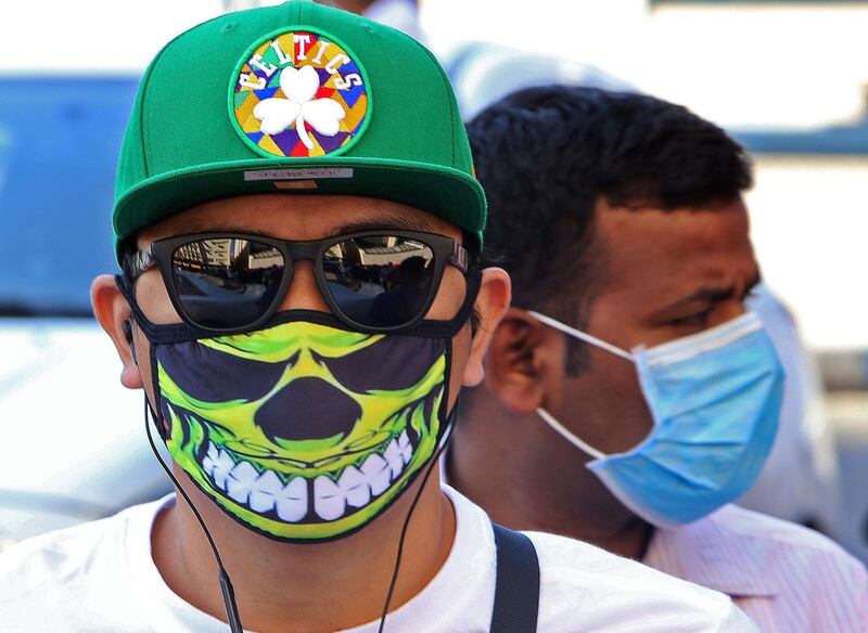 People wearing protective masks are seen on a street in Kuwait City on March 2, 2020, amid a global outbreak of the novel Coronavirus. / AFP / YASSER AL-ZAYYAT
