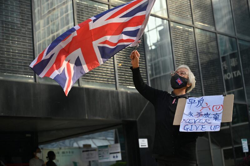 Activist Alexandra Wong, also known as Grandma Wong, waves the British flag outside the Wanchai district court in Hong Kong, on December 13, 2021, where activists were being tried for taking part in a banned vigil. AFP