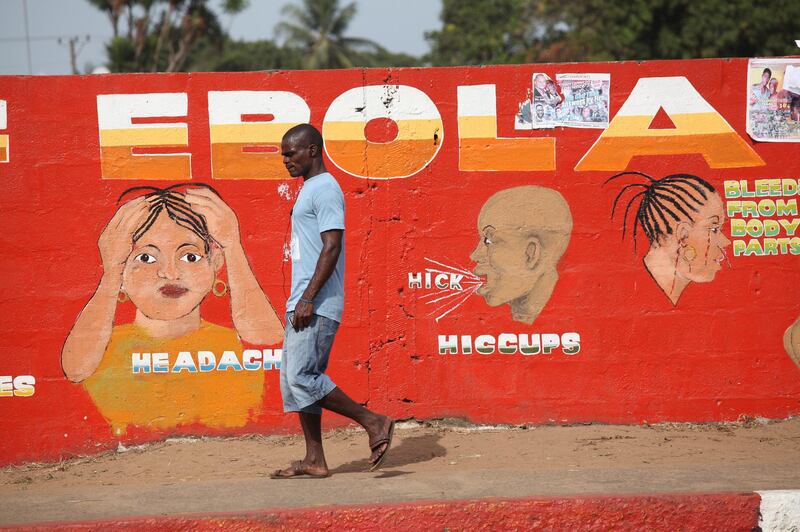 A Liberian man walks by an Ebola awareness painting on a wall in downtown Monrovia, Liberia, on March 22, 2015. EPA