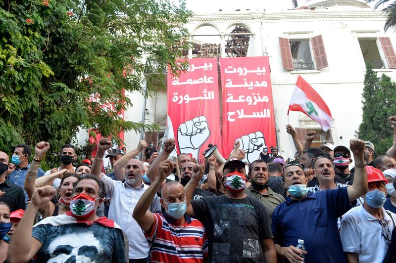 Protesters shout slogans next to banners reading in Arabic (left) 'Beirut capital of revolution' and (right) 'Beirut capital without weapons' as they enter the foreign ministry headquarters during a protest in Beirut, Lebanon. EPA