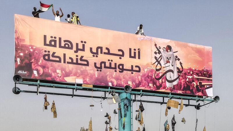 A picture taken during anti-regime protests on April 11, 2019 shows a huge billboard bearing an image of Alaa Salah, a Sudanese woman propelled to internet fame earlier this week after clips went viral of her leading powerful protest chants against Sudan's president, in the Sudanese capital Khartoum. Arabic writing next to her photo in a white gown reads: "My grandfather is Tarhaka, my beloved Kandaka". The Sudanese army is planning to make "an important announcement", state media said today, after months of protests demanding the resignation of longtime leader President Omar al-Bashir. In the clips and photos, the elegant Alaa Salah stands atop a car wearing a long white headscarf and skirt as she sings and works the crowd. Dubbed online as "Kandaka", or Nubian queen, she has become a symbol of the protests which she says have traditionally had a female backbone in Sudan. / AFP / -
