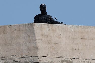 A Lebanese Hezbollah fighter stands guard on a rooftop outside Beirut on Tuesday. AP