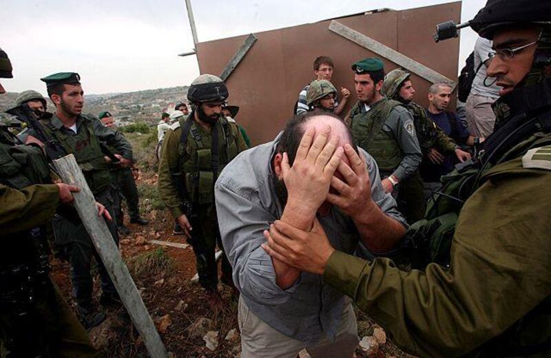 Israeli soldiers clash with an anti-settlement activist during a demonstration in Hebron.