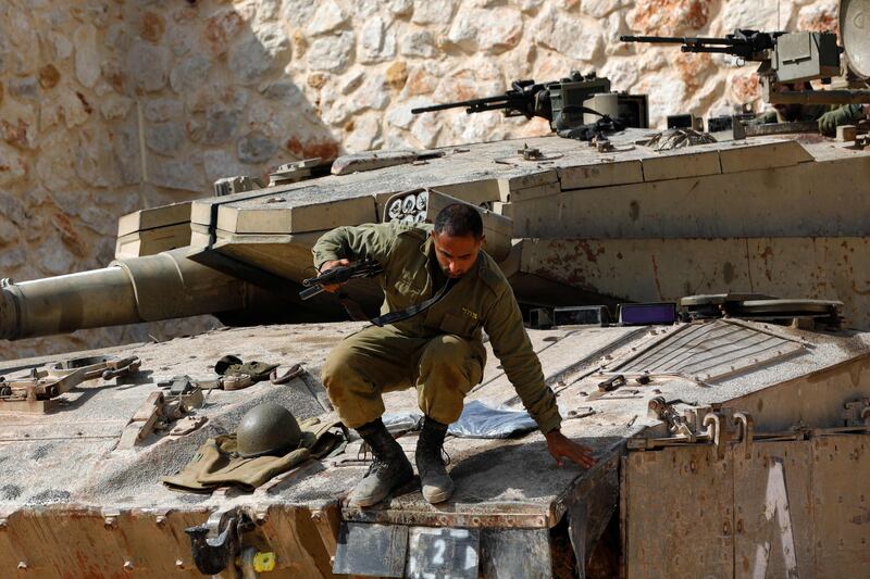 An Israeli soldier jumps off a Merkava tank at an undisclosed location on the border with Lebanon on October 22.  AFP