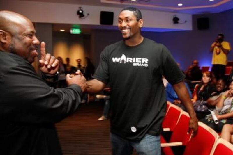 Los Angeles Lakers' Metta World Peace (R), formerly known as Ron Artest, is surprised by rapper WC following a news conference at the Grammy Museum in Los Angeles September 21, 2011. World Peace and his non-profit organization Xcel University gave away $285,000 in proceeds from the sale of his 2010 Los Angeles Lakers NBA championship ring to mental health charities from around the country. REUTERS/Jason Redmond (UNITED STATES - Tags: SPORT BASKETBALL ENTERTAINMENT) *** Local Caption ***  LAA11_USA-_0921_11.JPG