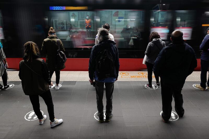 People wait on a tramway dock as they follow social-distancing rules, in the French Riviera city of Nice, southern France, on the first day of France's easing of lockdown measures against the coronavirus. AFP