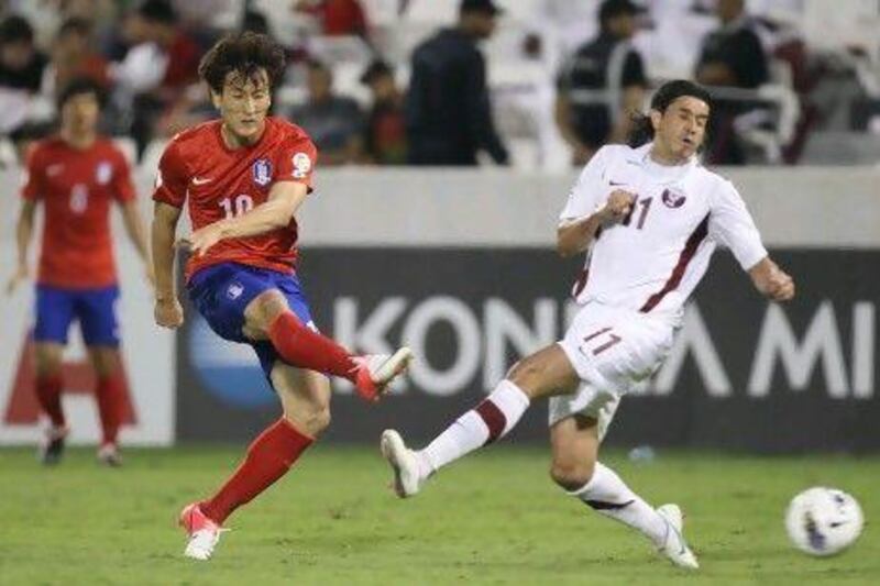 Qatar's Fabio Cesar, right, is not there in time to stop South Korea's Ji Dong Won's shot attempt during their game in Doha. Fifa and Uefa officials are discussing whether the 2022 World Cup in Qatar should be played late night or perhaps moved to January.