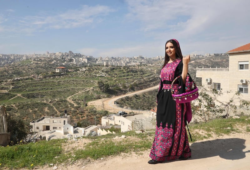 A woman poses dressed in Palestinian designer Khawla al-Tawil's pieces of traditional dresses and accessories, near her shop in Beit Sahour, south of Bethlehem in the occupied West Bank. All photos: AFP
