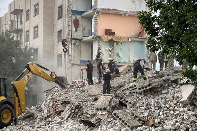 Firefighters and members of a rescue team clear the scene after a building was partialy destroyed following shelling, in Chasiv Yar, eastern Ukraine, on July 10, 2022.  AFP