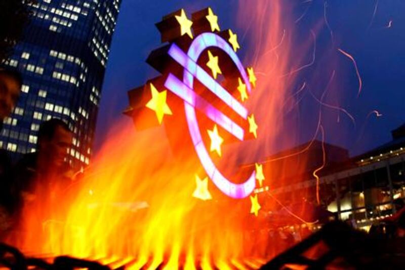 FOR USE IN YEAREND EDITIONS - FILE - In this Nov. 3, 2011 file photo, activists of the Occupy Frankfurt movement have set up a fire near the Euro sculpture in front of the European Central Bank in Frankfurt, Germany. (AP Photo/Michael Probst, File)