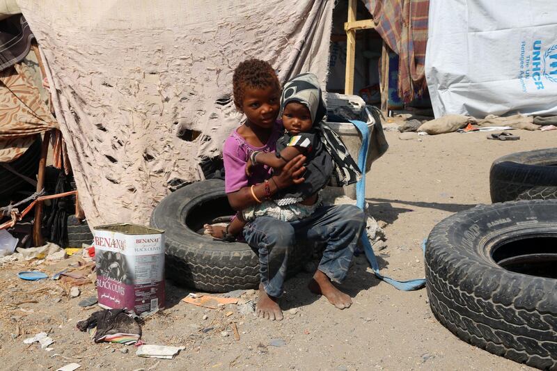 Displaced Yemeni children sit outside their makeshift shelter in an empty lot in the Yemeni coastal city of Hodeidah on November 16, 2017. / AFP PHOTO / ABDO HYDER