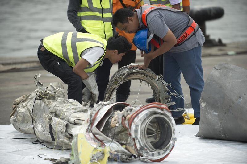 Investigators examine engine parts from the ill-fated Lion Air flight JT 610 at a port in Jakarta on November 7, 2018, after they were recovered from the bottom of the Java sea. - The Indonesian Lion Air jet that plunged into the Java Sea on October 29, killing all 189 on board, had an air speed indicator problem on its fatal flight and on three previous journeys, the country's transportation watchdog said on November 6. (Photo by BAY ISMOYO / AFP)