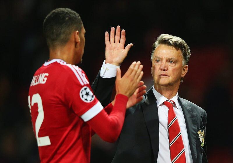 Manchester United manager Louis van Gaal goes to high-five Chris Smalling after their Champions League win over Club Brugge on Tuesday. Alex Livesey / Getty Images / August 18, 2015 