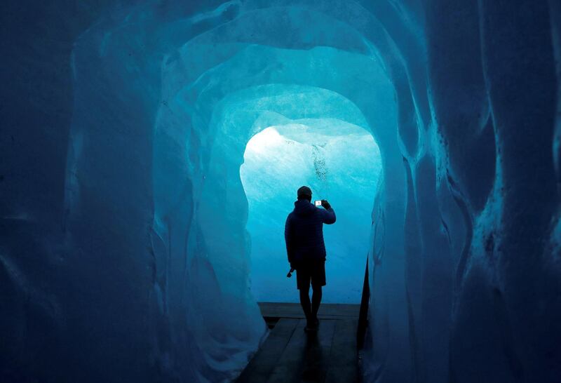 A tourist takes a picture in the Ice Cave at the Rhone Glacier in Furka, Switzerland. Denis Balibouse / Reuters