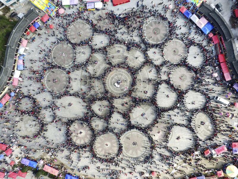 Spectators watch as thousands of people of Miao ethnicity gather in circles to dance and play folk instruments known as lusheng at a public square in Zhouxi township in Kaili in southwestern China’s Guizhou province. The Lusheng festival is an annual festival and gathering for China’s Miao ethnic minority group. Chinatopix via AP / February 16, 2017