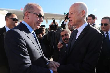 Tunisian President Kais Saied, right, welcomes Turkish President Recep Tayyip Erdogan on his arrival in Tunis. AFP