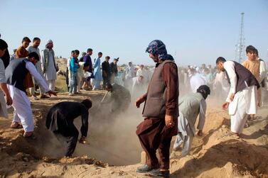 Afghan men bury the bodies of security forces killed in a suicide attack in Kunduz province north of Kabul in September. AP