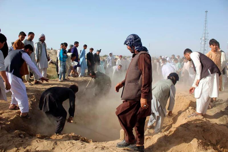 Afghan men bury the bodies of security forces killed in a suicide attack on Saturday ,in Kunduz province, north of Kabul, Afghanistan, Sunday, Sept. 1, 2019. The Taliban attacked a second Afghan city in as many days on Sunday and killed several members of security forces, officials said, even as Washington's peace envoy said the U.S. and the militant group are "at the threshold of an agreement" to end America's longest war. (AP Photo/Bashir Khan Safi)